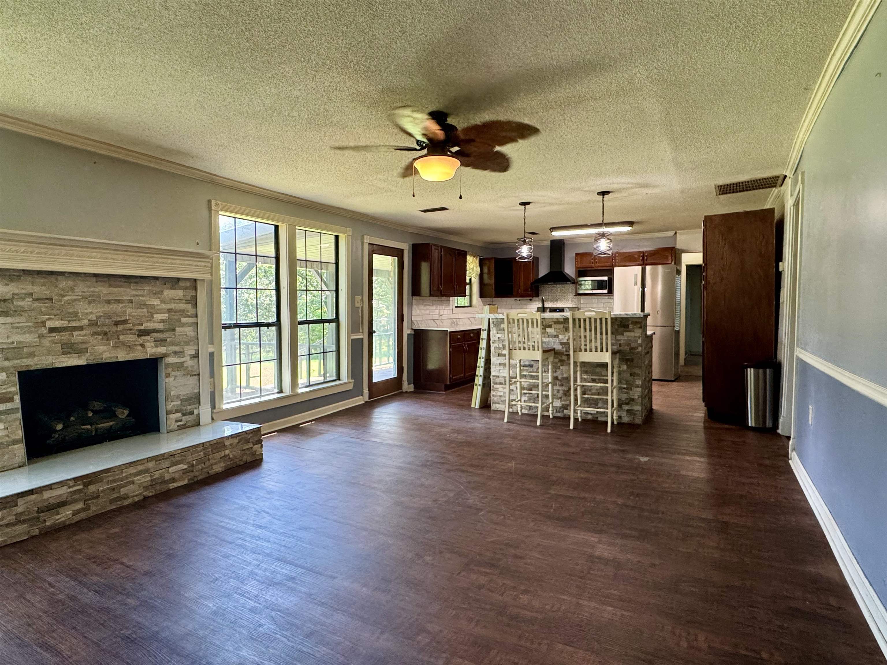 13000 Highway 57 Middleton, TN 38052 - Photo 18 of 40 a view of a livingroom with a fireplace a ceiling fan a fireplace and windows