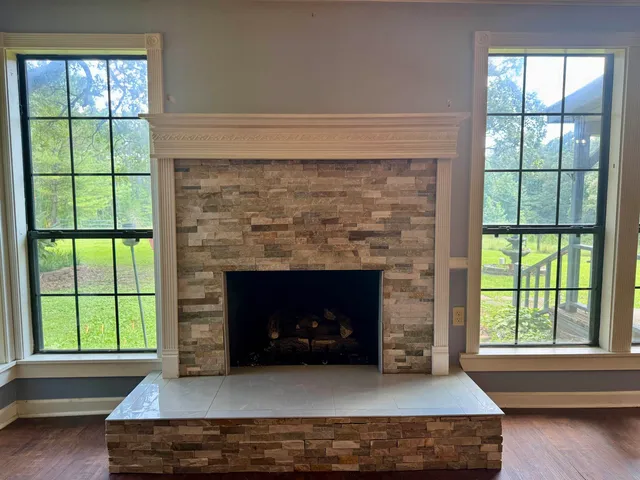 a living room with a fireplace and a large window