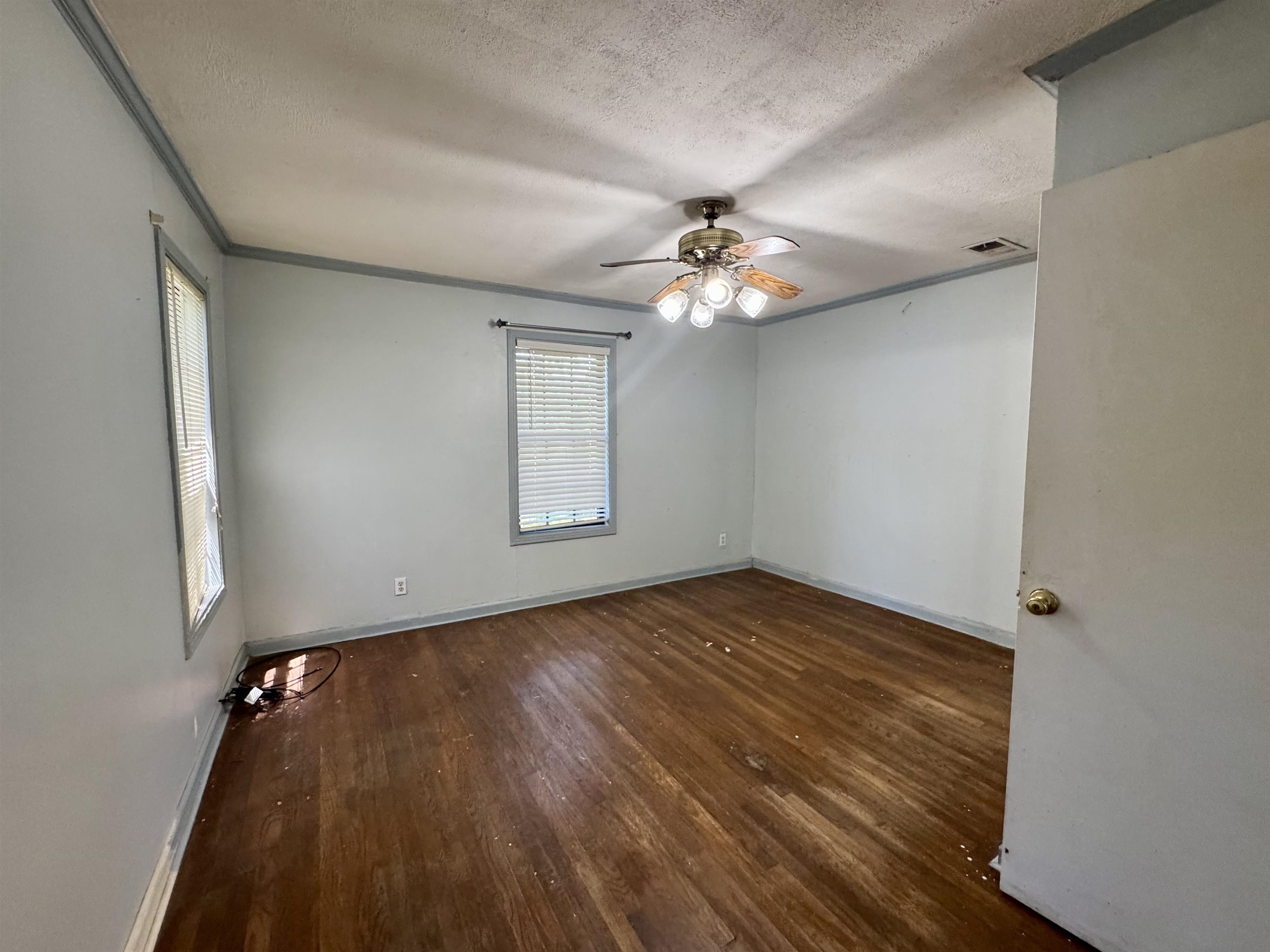 13000 Highway 57 Middleton, TN 38052 - Photo 24 of 40 an empty room with wooden floor chandelier fan and windows