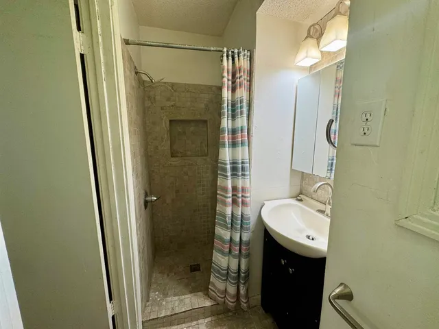 a bathroom with a granite countertop sink toilet and shower