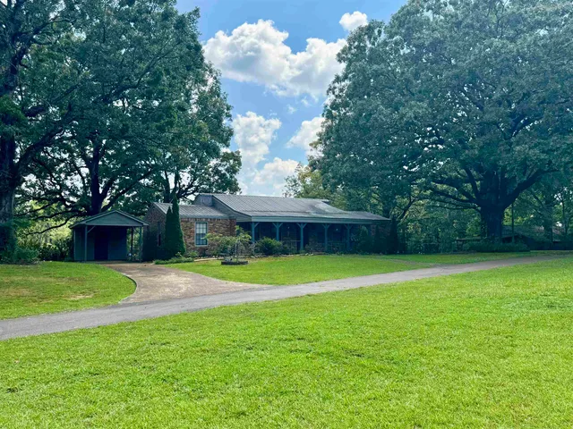 a front view of a house with a yard and trees