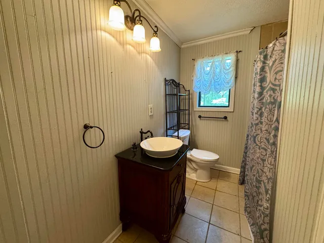 a bathroom with a granite countertop toilet and a sink
