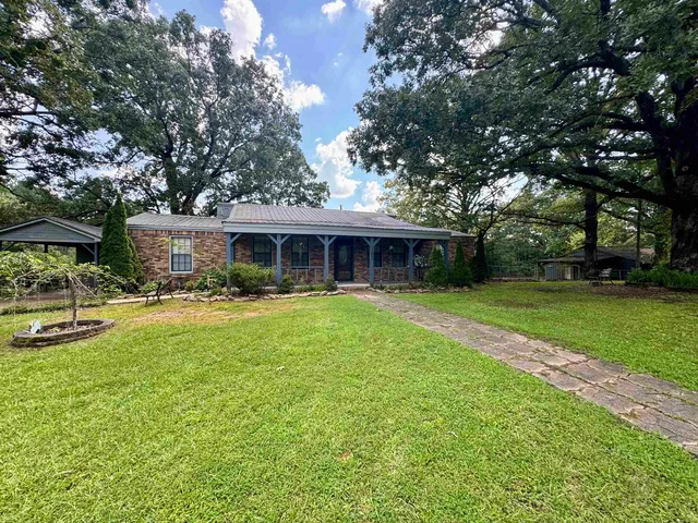 a front view of house with yard and green space