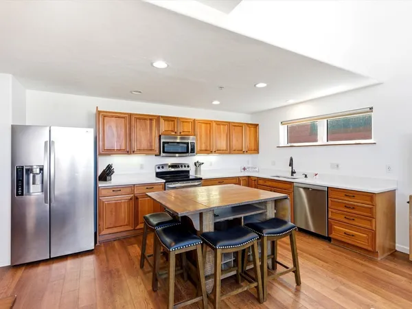 a room with stainless steel appliances a table and chairs