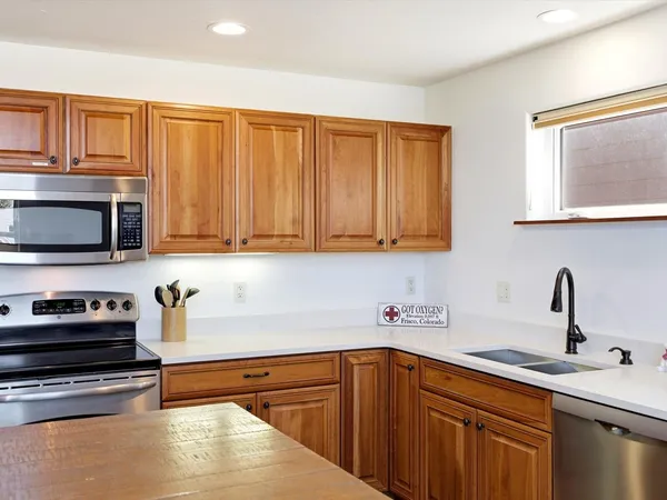 a kitchen with stainless steel appliances wooden cabinets and a sink