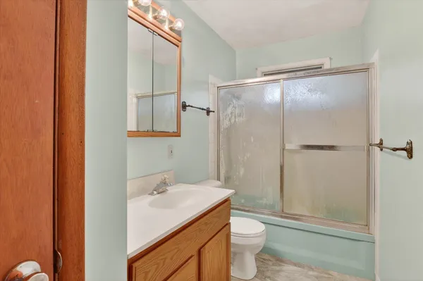 a bathroom with a granite countertop sink toilet and shower