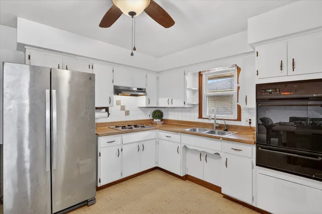a kitchen with granite countertop a sink stainless steel appliances and cabinets