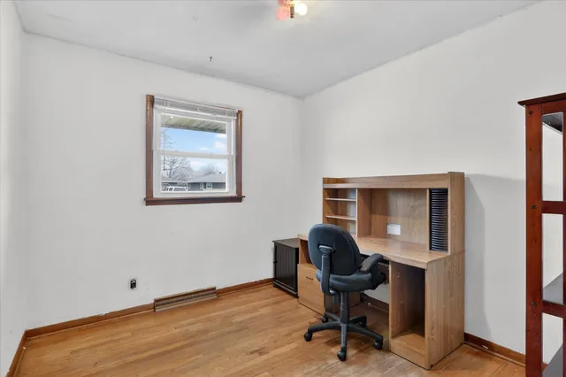 a view of a bedroom with wooden floor and windows