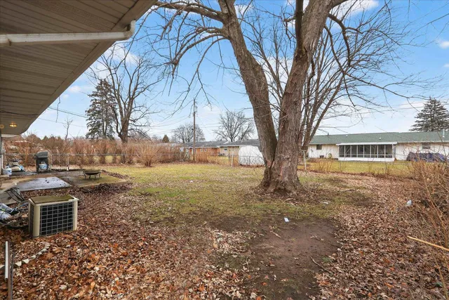 an aerial view of a house with a yard and large trees