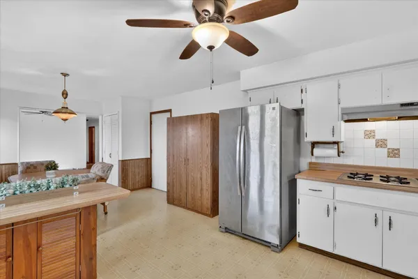 a kitchen with stainless steel appliances granite countertop a refrigerator a sink and white cabinets