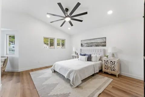 a bedroom with a large bed chandelier and a window