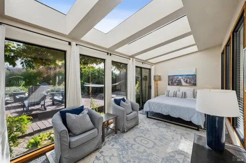 a bedroom with furniture and a large window