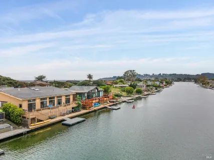 an aerial view of a house with a garden and lake view