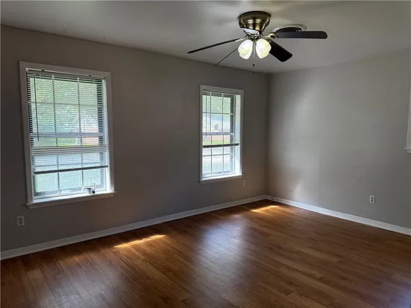 a window in an empty room with wooden floor