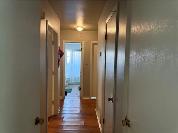 a view of a hallway with wooden floor