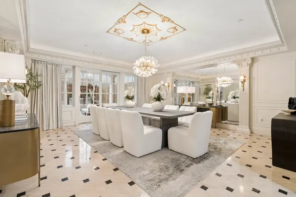 a dining room with wooden floor and a chandelier