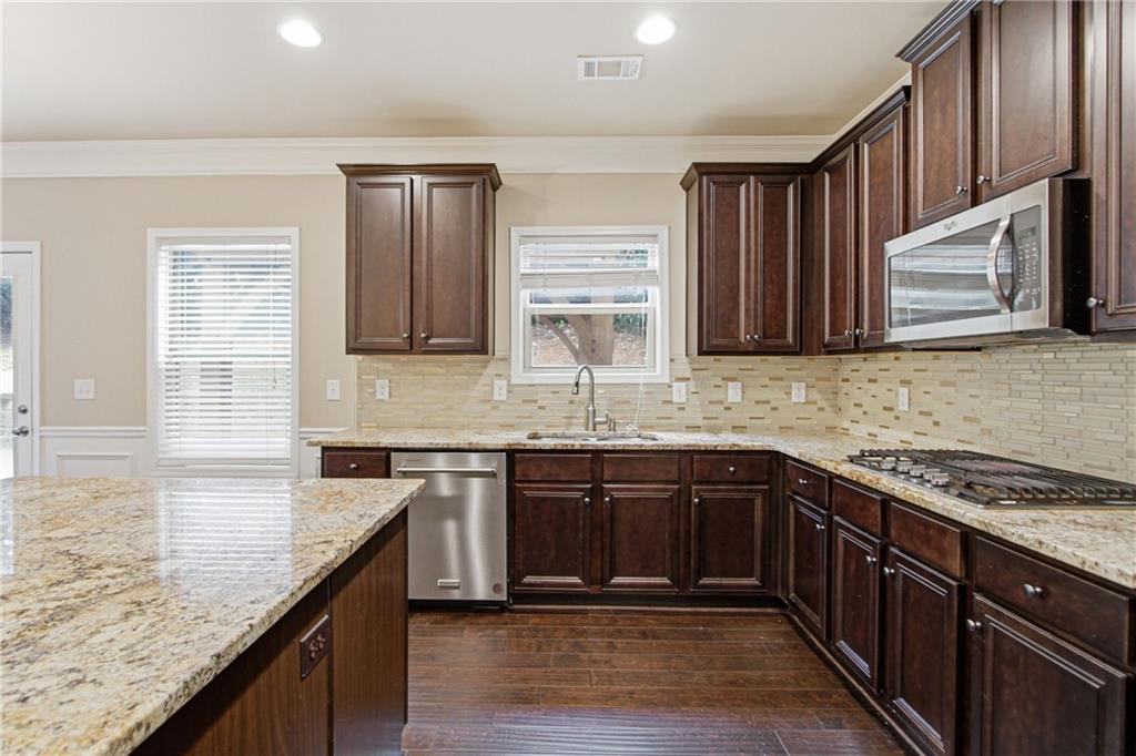 114 Madison Street Canton, GA 30115 - Photo 2 of 39 a kitchen with stainless steel appliances granite countertop a sink stove and cabinets