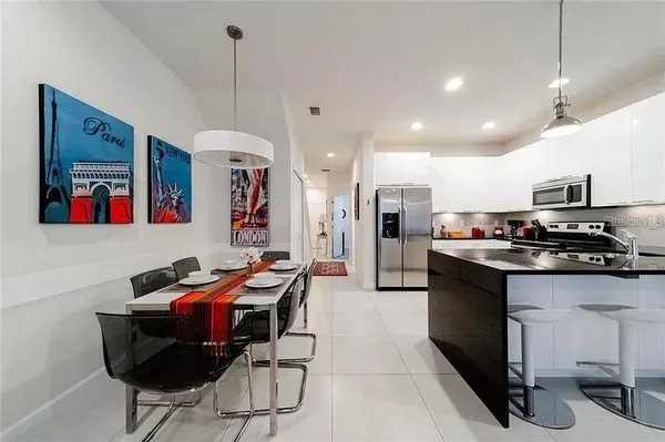 a kitchen with stainless steel appliances kitchen island granite countertop a sink and a refrigerator