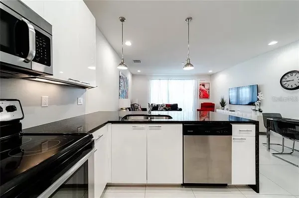 a kitchen with stainless steel appliances granite countertop a sink a stove and a microwave