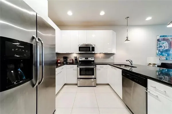 a kitchen with granite countertop a refrigerator and a sink