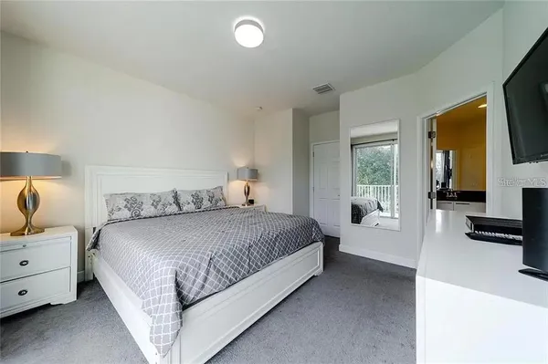 a spacious bedroom with a bed and large windows