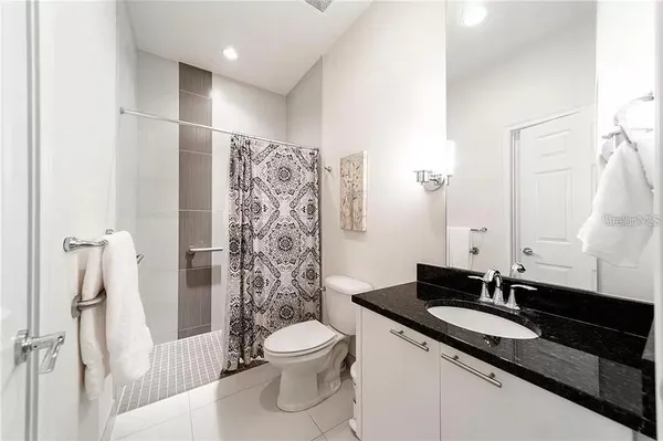 a bathroom with a granite countertop sink toilet and shower