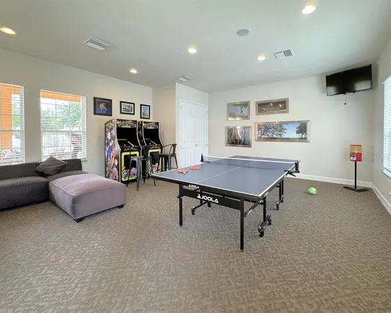a living room with furniture pool table and a large window