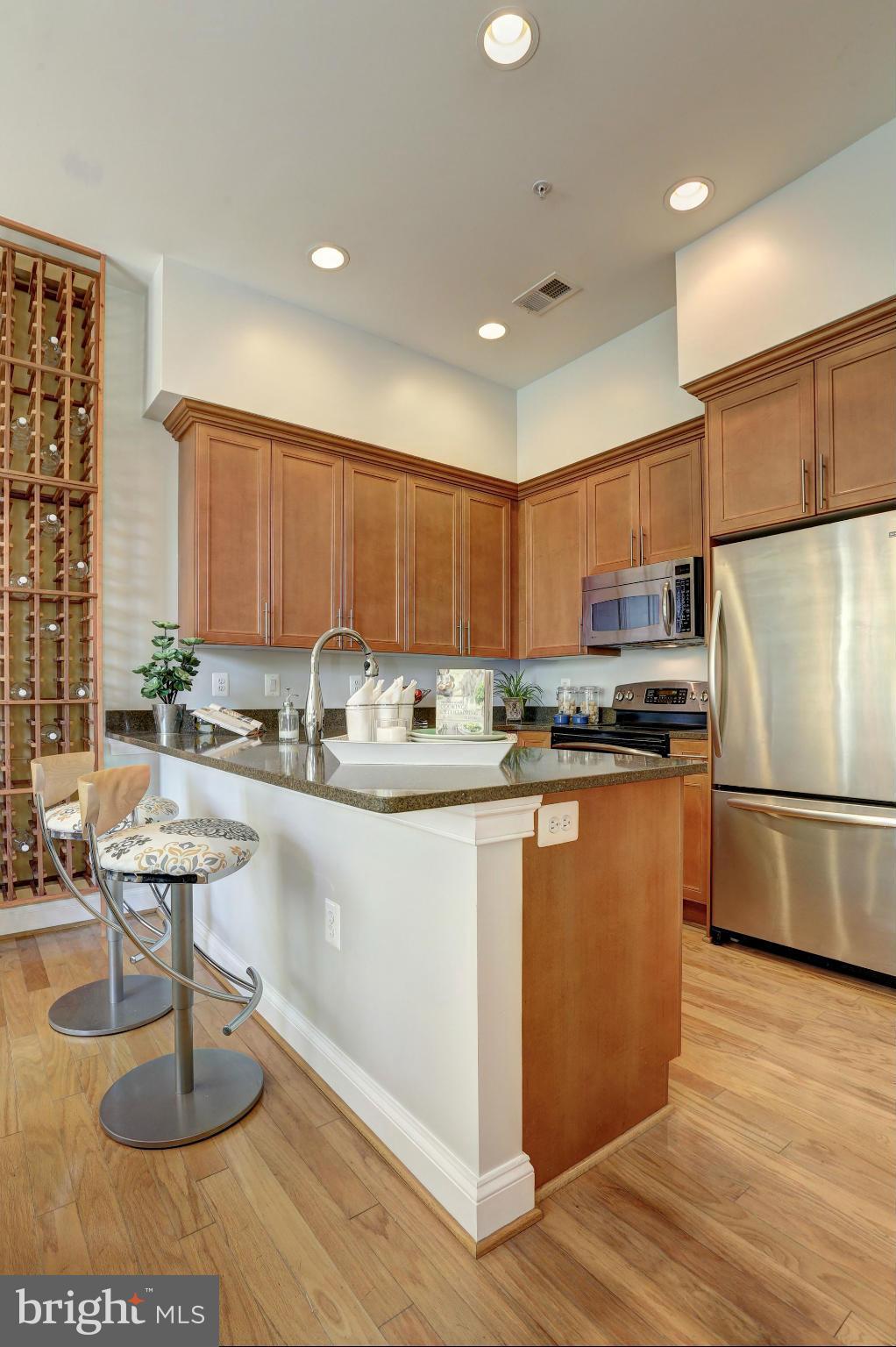1407 W Street Northwest, Unit 202 Washington, DC 20009 - Photo 17 of 30 a kitchen with stainless steel appliances granite countertop a refrigerator sink and cabinets