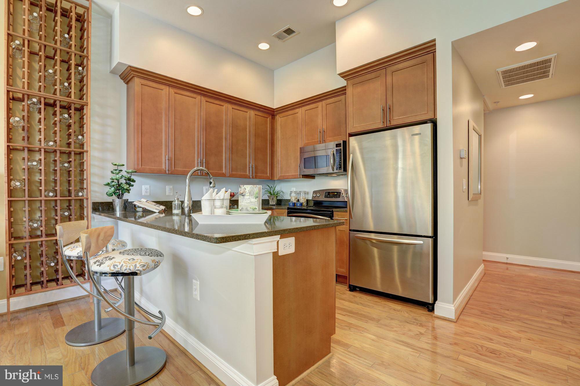 1407 W Street Northwest, Unit 202 Washington, DC 20009 - Photo 8 of 30 a kitchen with a refrigerator a sink and cabinets