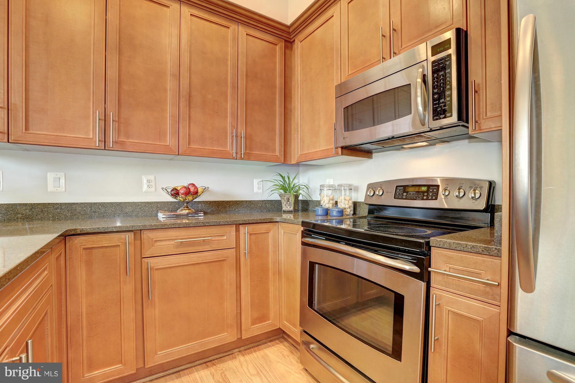 1407 W Street Northwest, Unit 202 Washington, DC 20009 - Photo 10 of 30 a kitchen with stainless steel appliances granite countertop a stove microwave and sink