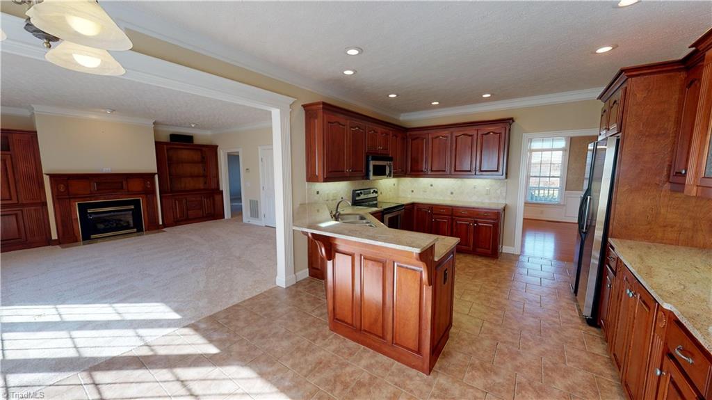 256 Stonecroft Road Mount Airy, NC 27030 - Photo 5 of 30 Kitchen features custom cherry cabinets, granite countertops, tile backsplash, tile floor, stainless appliances, garbage disposal, under cabinets lighting and cabinet organizers!