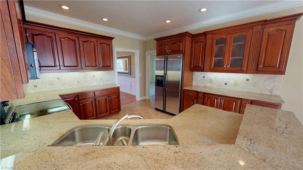 256 Stonecroft Road Mount Airy, NC 27030 - Photo 6 of 30 Kitchen features custom cherry cabinets, granite countertops, tile backsplash, tile floor, stainless appliances, garbage disposal, under cabinets lighting and cabinet organizers!