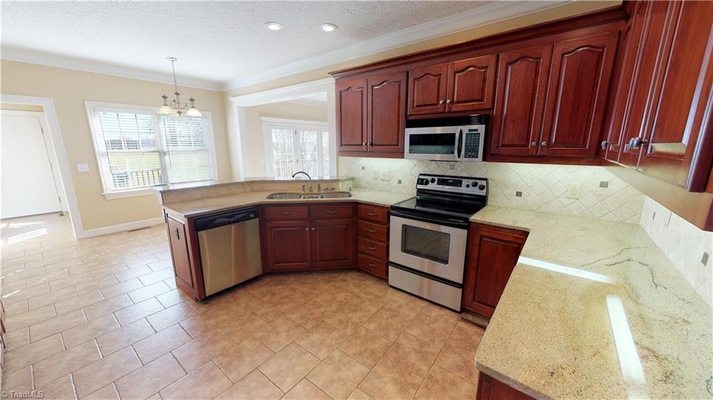 256 Stonecroft Road Mount Airy, NC 27030 - Photo 7 of 30 Kitchen features custom cherry cabinets, granite countertops, tile backsplash, tile floor, stainless appliances, garbage disposal, under cabinets lighting and cabinet organizers!