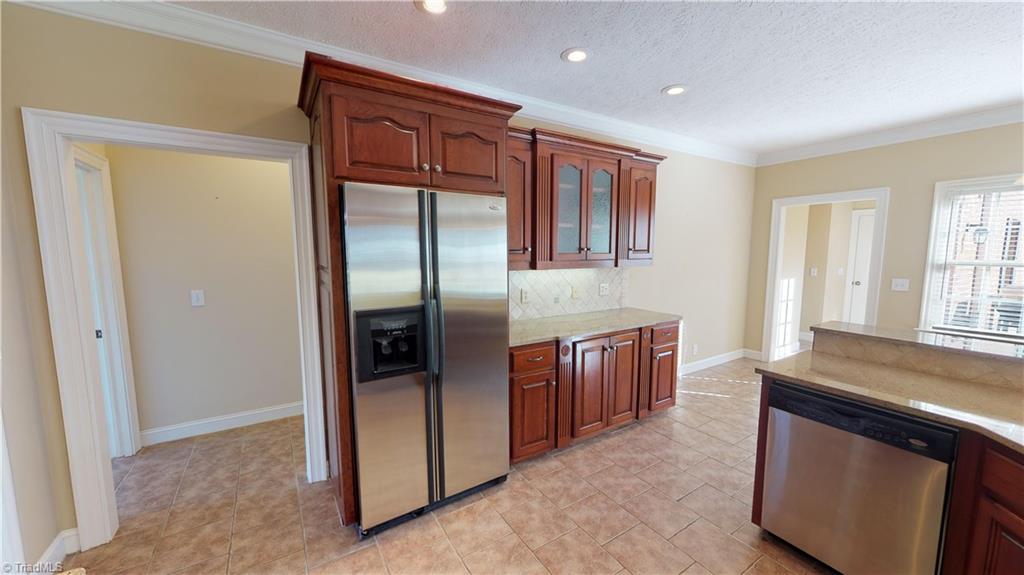 256 Stonecroft Road Mount Airy, NC 27030 - Photo 8 of 30 Kitchen features custom cherry cabinets, granite countertops, tile backsplash, tile floor, stainless appliances, garbage disposal, under cabinets lighting and cabinet organizers!