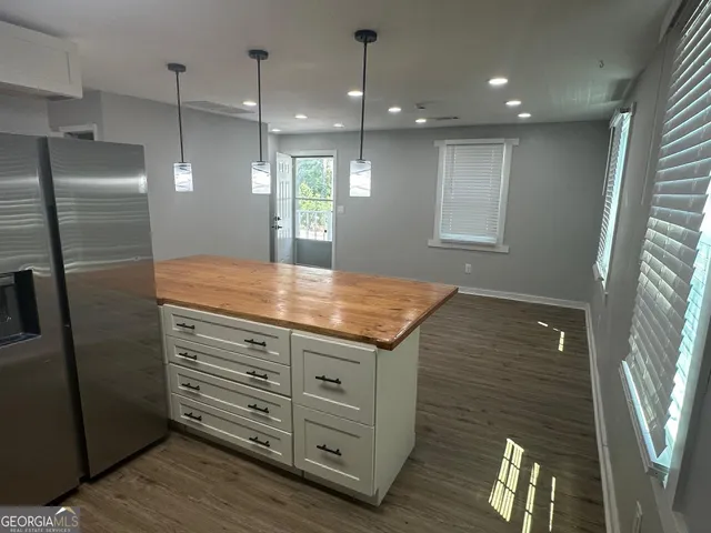 a large white kitchen with a sink and dishwasher a stove with wooden floors