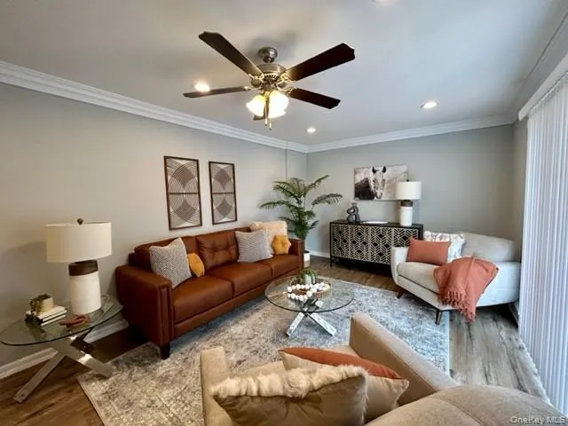 a living room with furniture and a ceiling fan