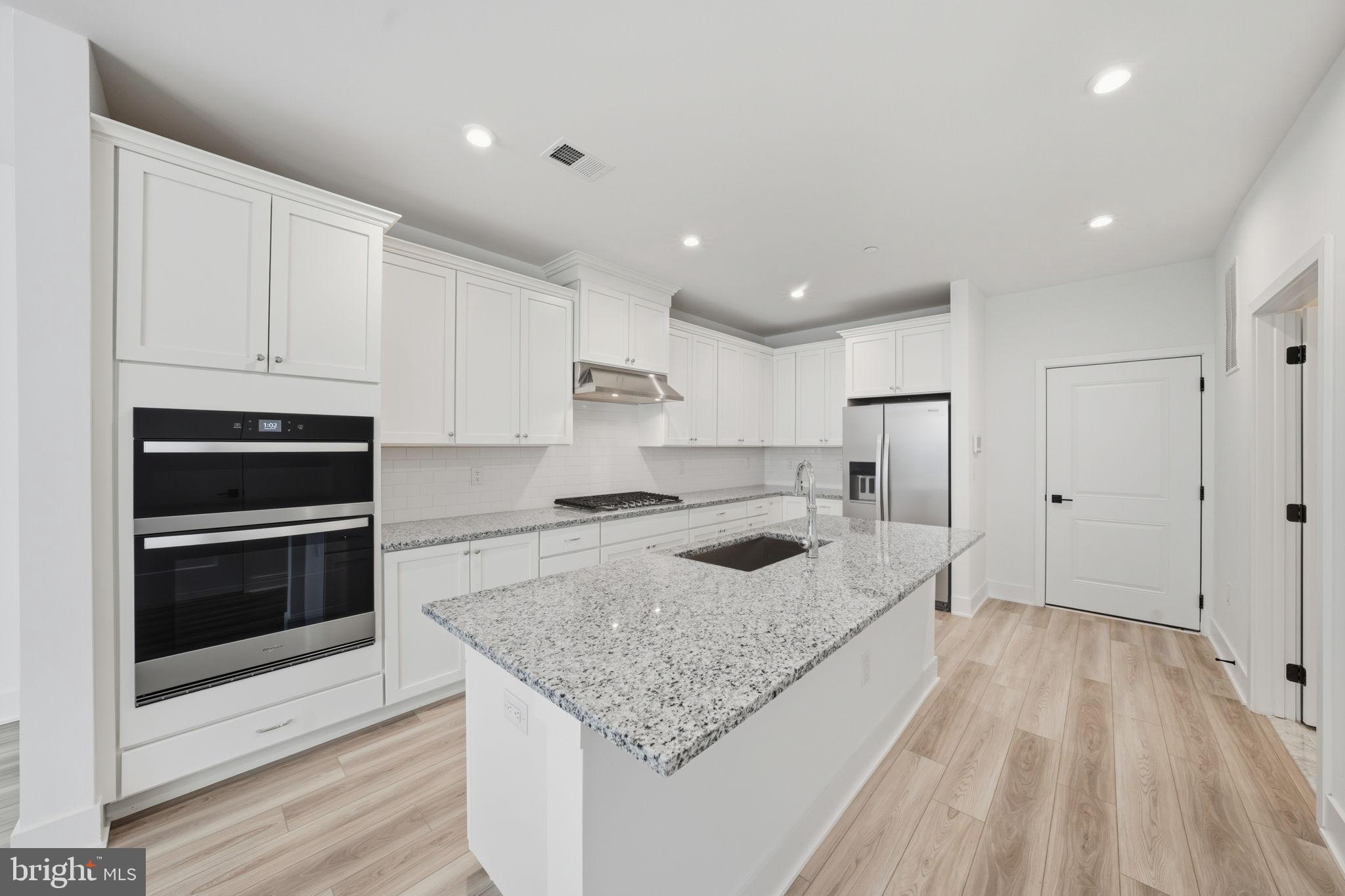 8101 Donatello Drive Princeton, NJ 08540 - Photo 10 of 26 a large kitchen with stainless steel appliances granite countertop a large counter top and a stove top oven