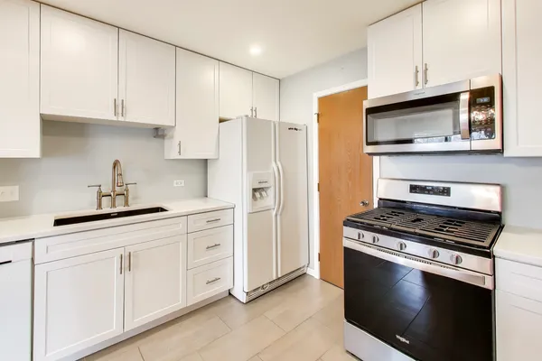 a kitchen with cabinets stainless steel appliances and a sink