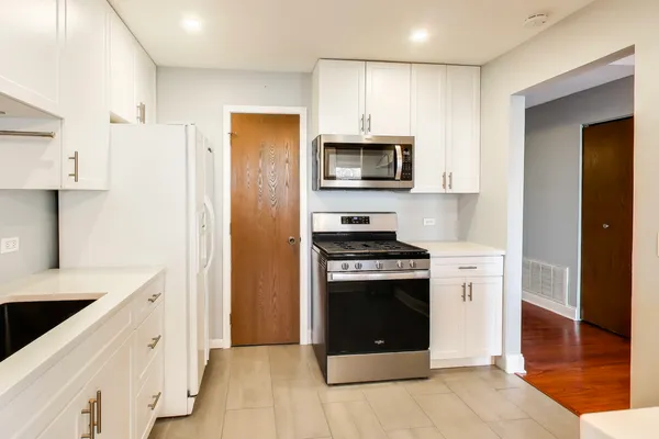 a kitchen with stainless steel appliances a stove a sink and a refrigerator