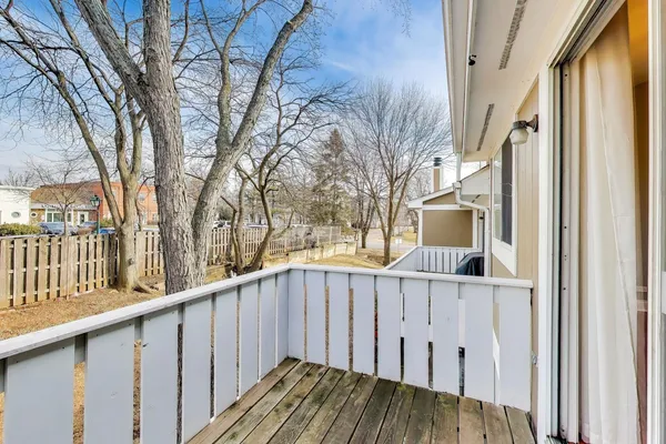 a view of a house with wooden fence and iron stairs