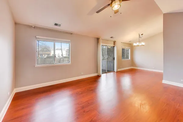 a view of an empty room with window and wooden floor