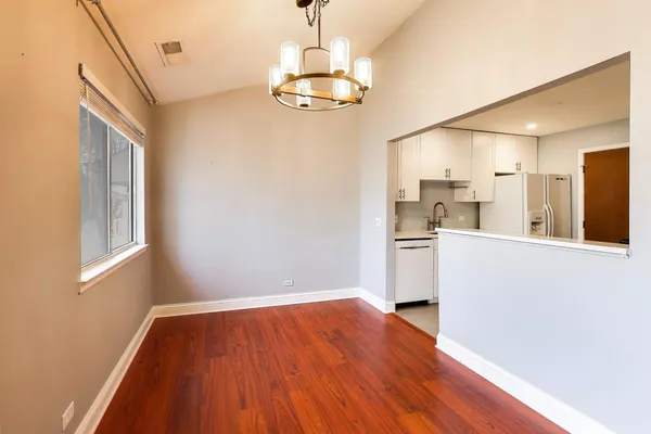 a view of a kitchen with wooden floor and a window