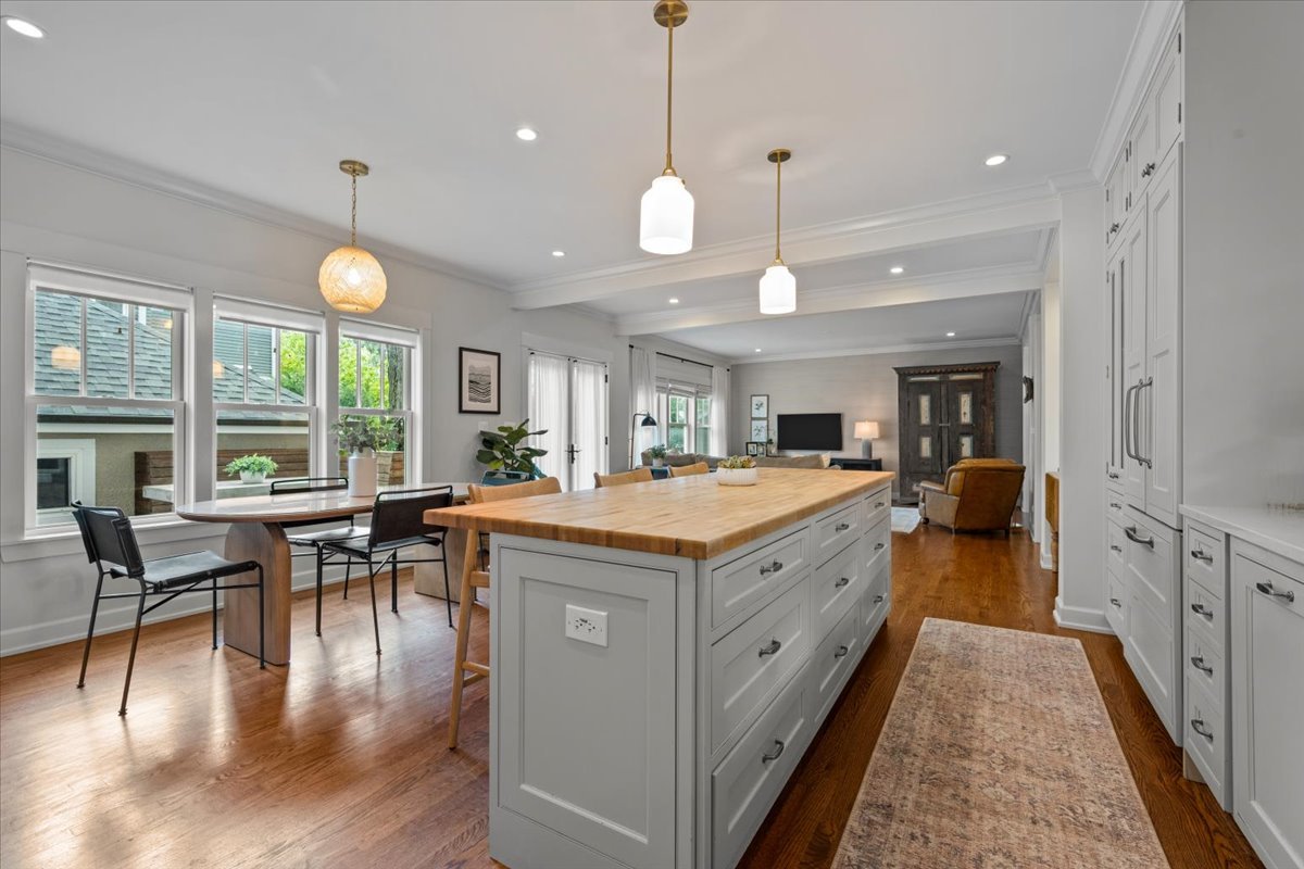1303 Maple Avenue Wilmette, IL 60091 - Photo 6 of 33 a large kitchen with kitchen island a large island in the center a sink a window appliances and living room view