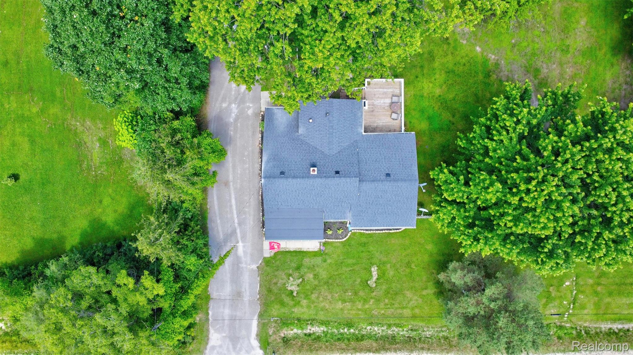 5244 Oleksyn Road Flint, MI 48504 - Photo 47 of 70 Property featuring a dark shingle roof, a rear deck, and a paved driveway