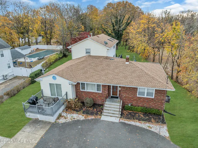 a view of a house with a yard and large tree