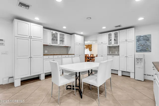 a kitchen with white cabinets and refrigerator