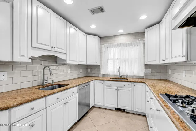 a kitchen with granite countertop white cabinets white stainless steel appliances and sink