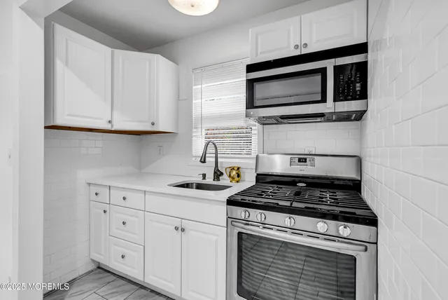a kitchen with appliances a sink and cabinets