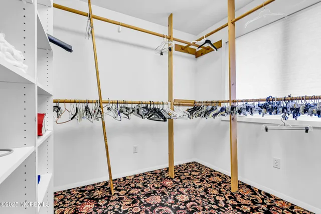 a view of walk in closet with clothes and shoes
