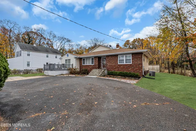 a front view of a house with a garden and trees